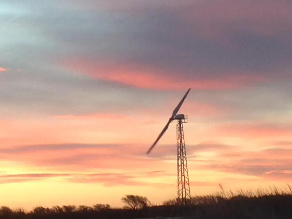 Sunset over the fields with a wind turbine