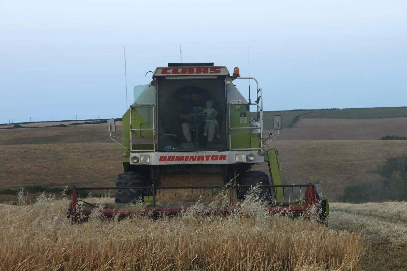 A combine harvester cutting a field of barley